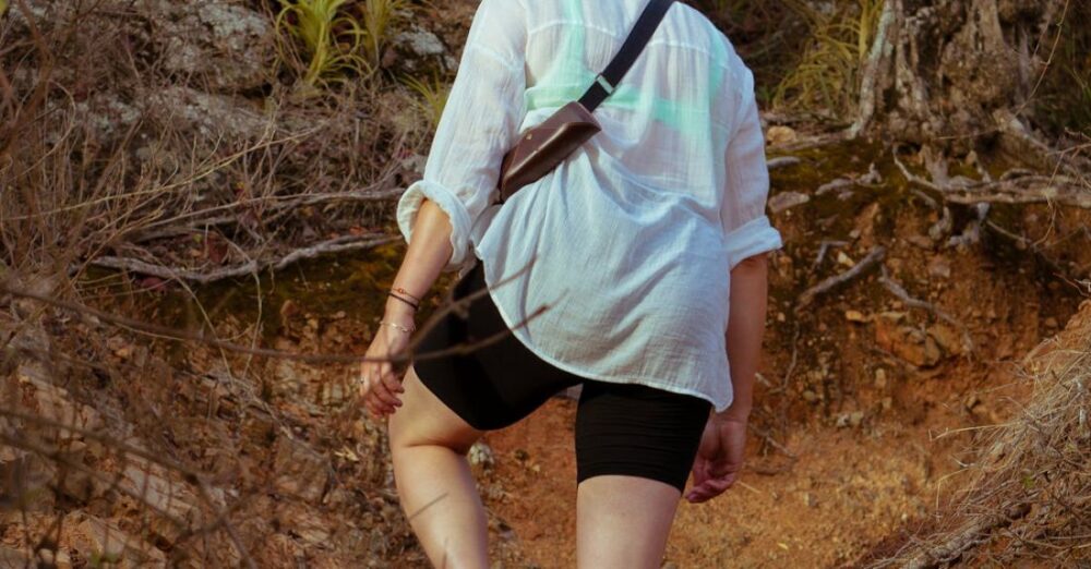 Adventure Tourism - A woman walking down a trail in the woods