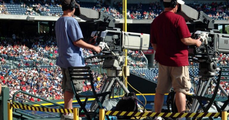 Media Platforms - 2 Camera Man Standing in a Green Metal Stage during Daytime