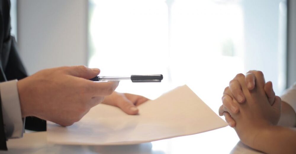 Financial Markets - Crop businessman giving contract to woman to sign