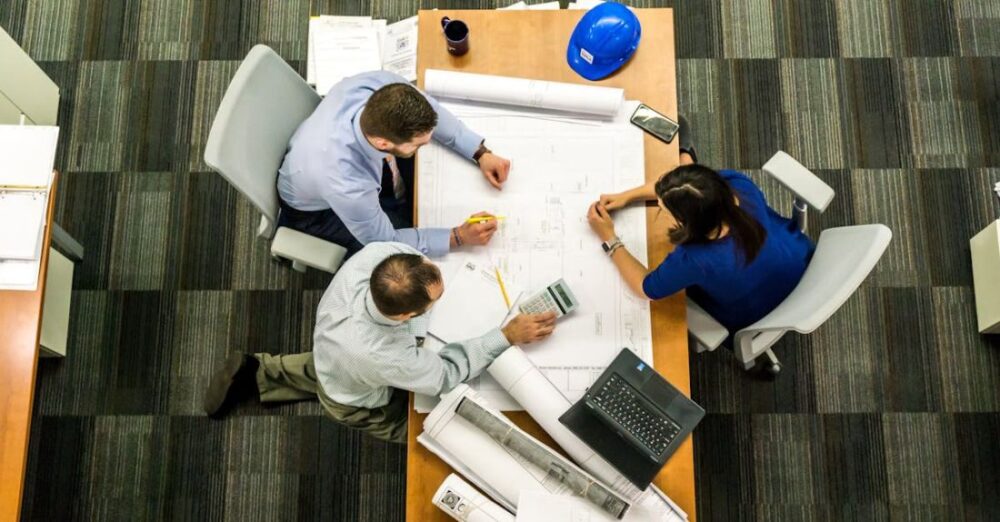 Business Management - Three People Sitting Beside Table