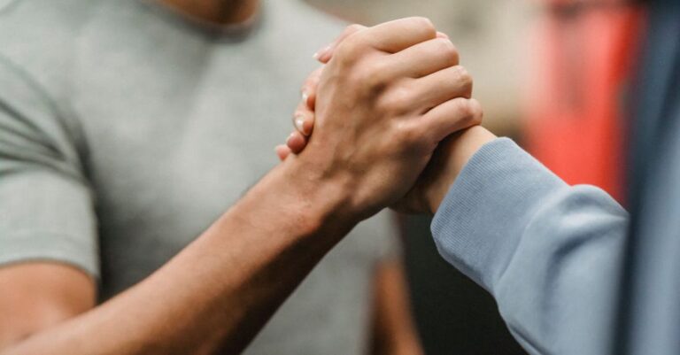 Training Techniques - Crop sportive couple clasping hands in gym