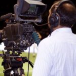 Sports Media - Man with a TV Camera Filming a Soccer Match