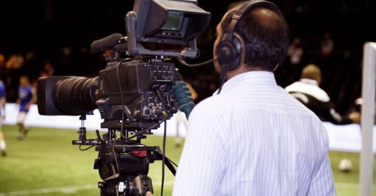 Sports Media - Man with a TV Camera Filming a Soccer Match