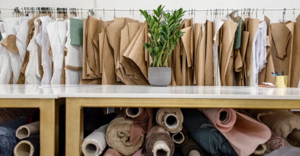 Job Market - Rolls of assorted fabrics and textiles and sewing patterns inside tailor atelier