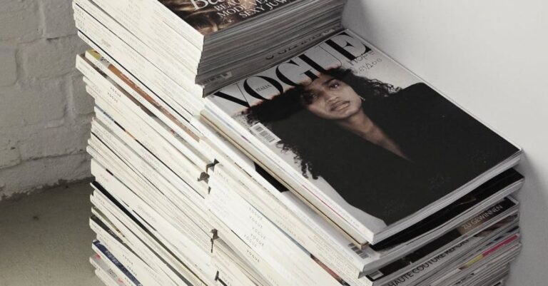 Contemporary Literature - High angle many fashion magazines stacked on floor against white brick wall in studio