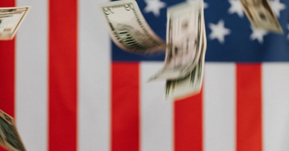 Inflation - National flag of United States of America on background and dollars falling down